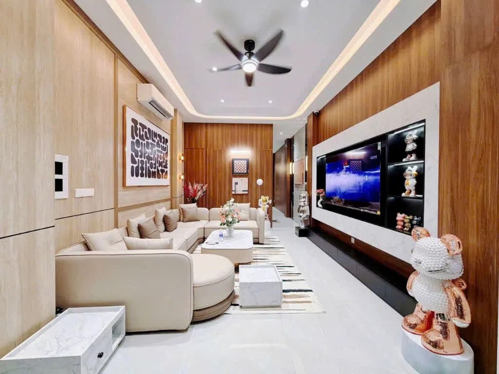 Phòng khách nhà mặt tiền đường số 44 Tân Quy Đông Quận 7 với sofa, tivi lớn và quạt trần