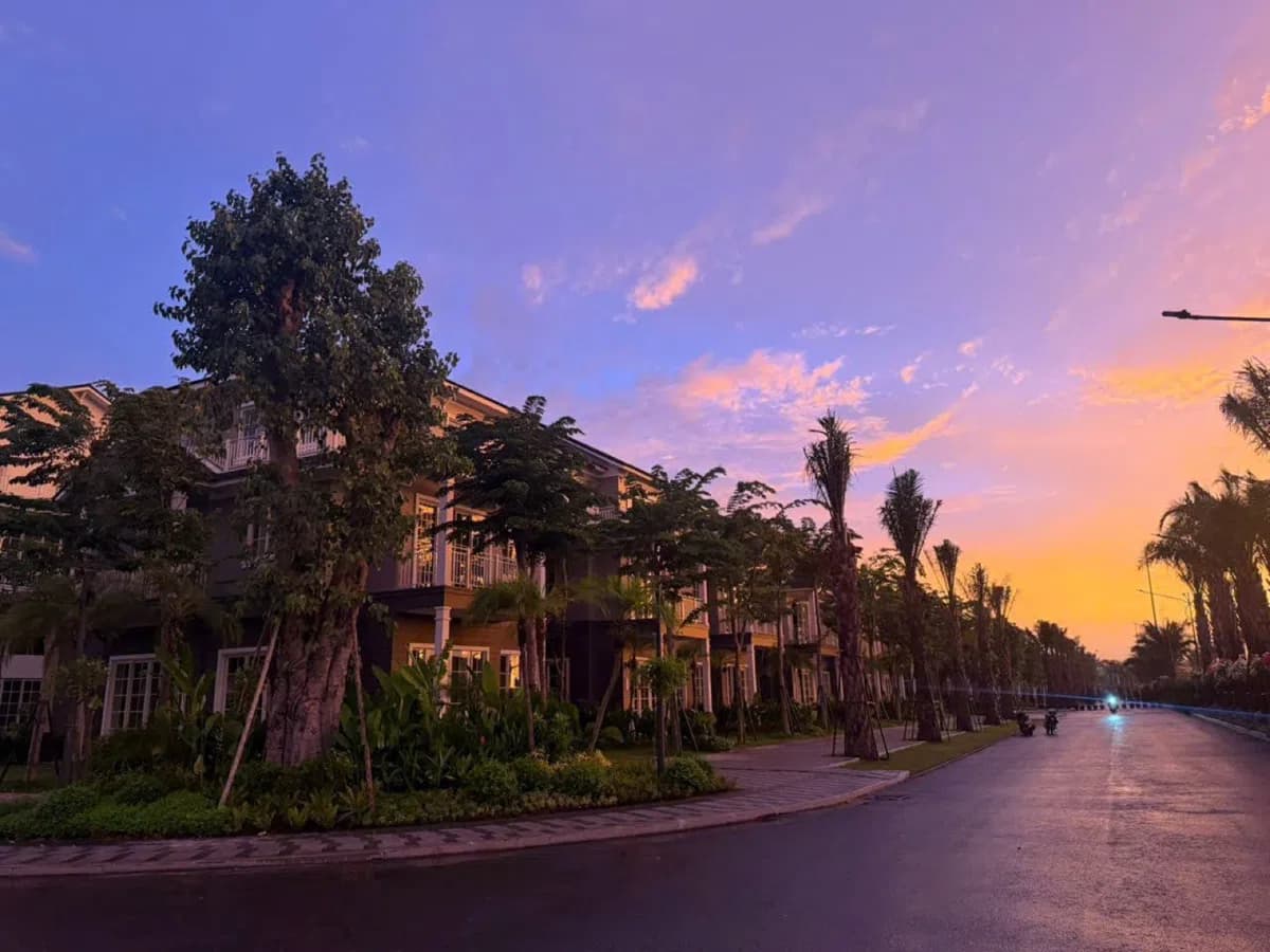 Hoàng hôn tím hồng trên dãy nhà và hàng cây tại Eco Retreat