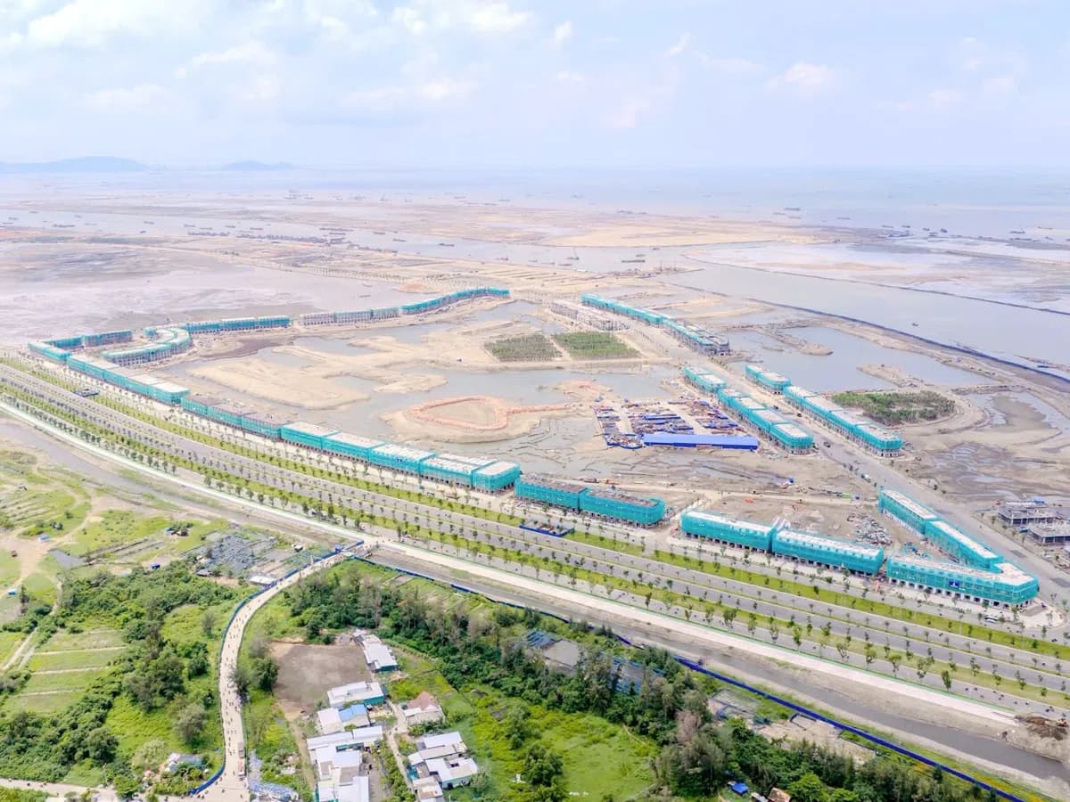 Hình ảnh thực tế tiến độ Vinhomes Cần Giờ tháng 10/2026 nhìn từ trên cao: đại lộ, các dãy nhà bọc lưới, bãi bồi
